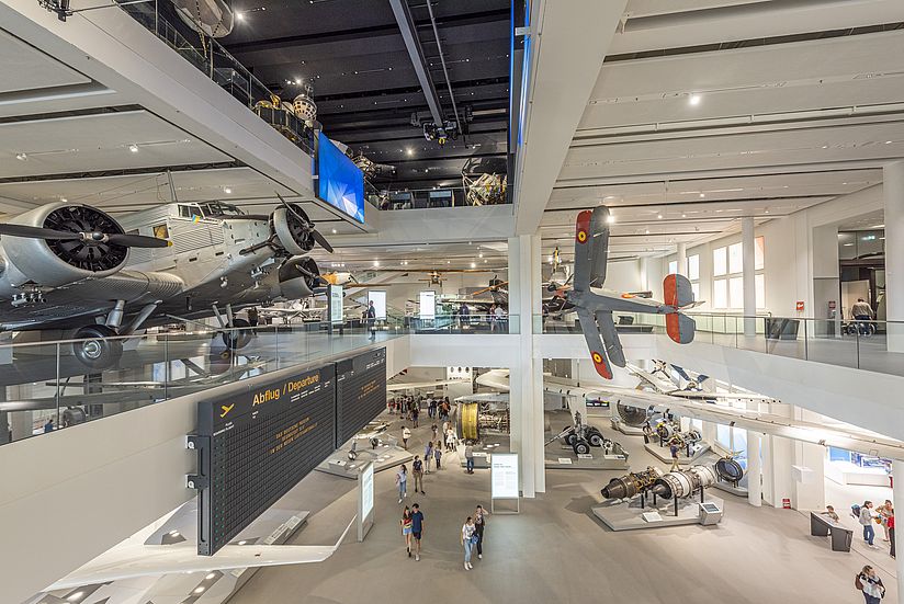 Fluggeräte stehen und hängen von der Decke. Die Halle ist vom Boden, Ebene 0 bis zur Decke, Ebene 2 geöffnet. Die Ausstellungen auf Ebene 1 und 2 gruppieren sich rund um diese Öffnung.